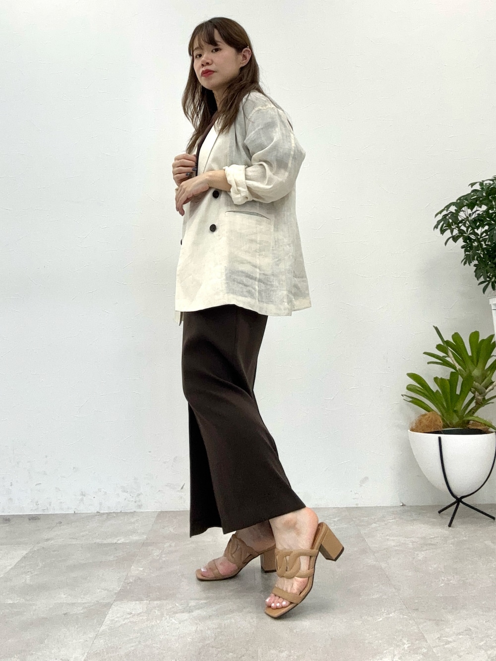 ブラウン系のサンダル、ブラウン系のスカート、ベージュ系のテーラードジャケットを着用したレディースの夏コーディネートの2枚目の写真