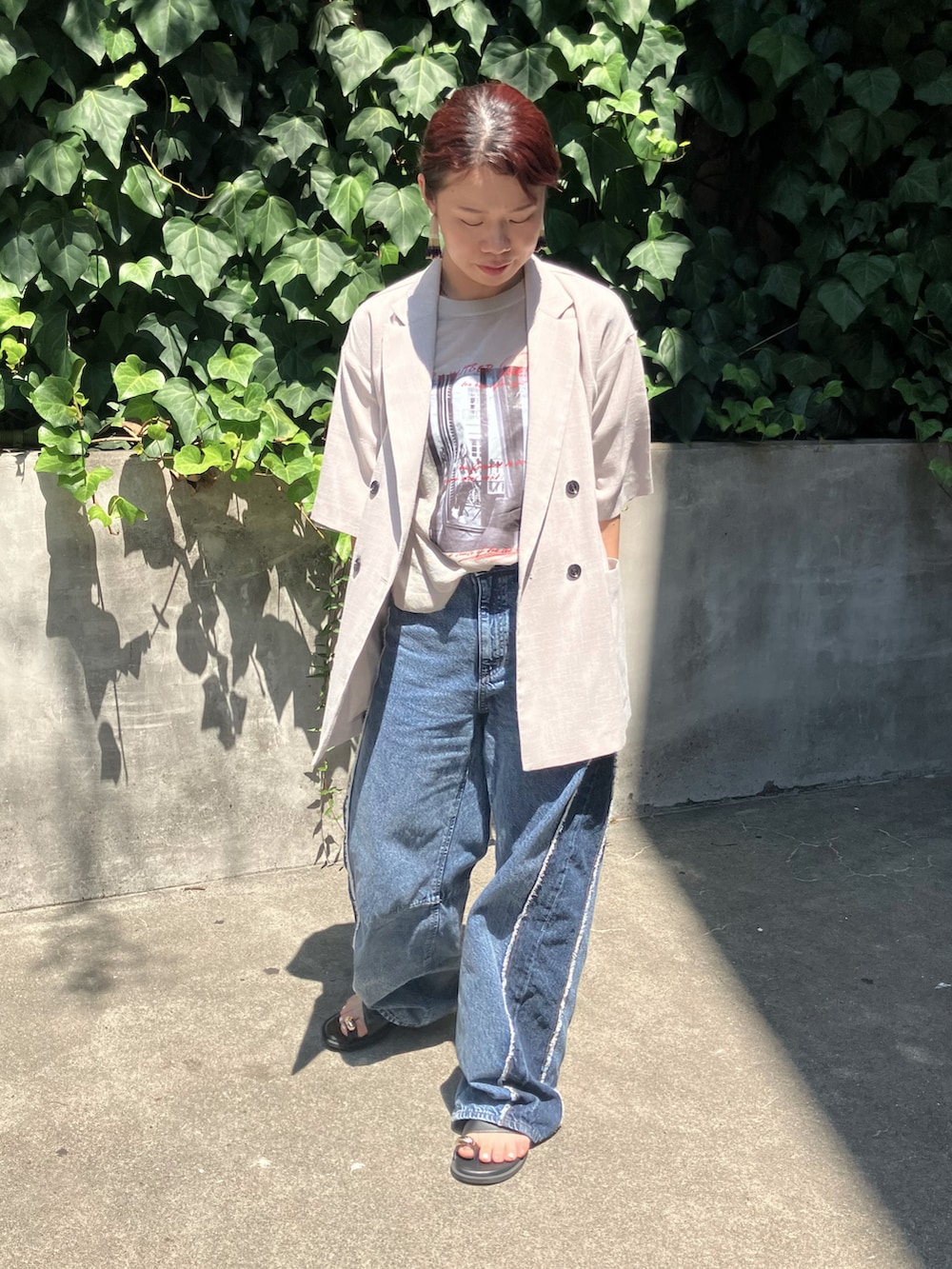 ブルー系のデニムパンツ、イエロー系のニット/セーター、ブラック系のサンダルを着用したレディースの夏コーディネートの2枚目の写真