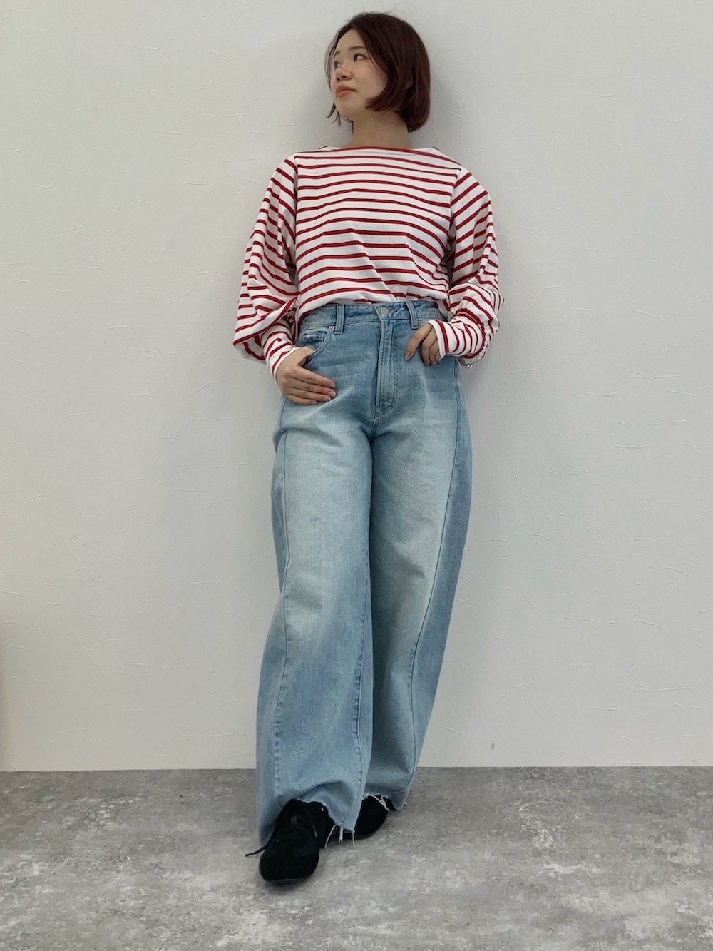 レッド系のTシャツ/カットソー、ブルー系のデニムパンツ、ブラック系のスニーカーを着用したレディースの冬コーディネートの2枚目の写真