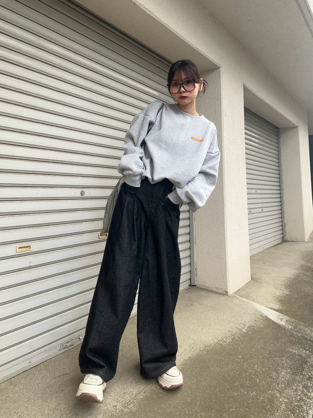 グレー系のスウェット、ホワイト系のスニーカー、グレー系のバッグを着用したレディースの冬コーディネートの2枚目の写真