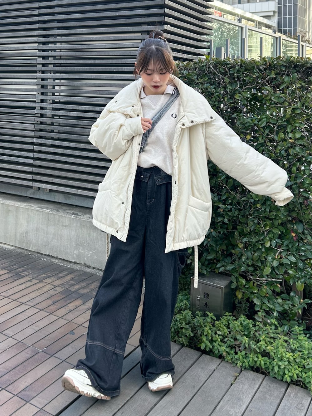 ホワイト系のスニーカー、ブラック系のデニムパンツ、ホワイト系のスウェットを着用したレディースの冬コーディネートの2枚目の写真