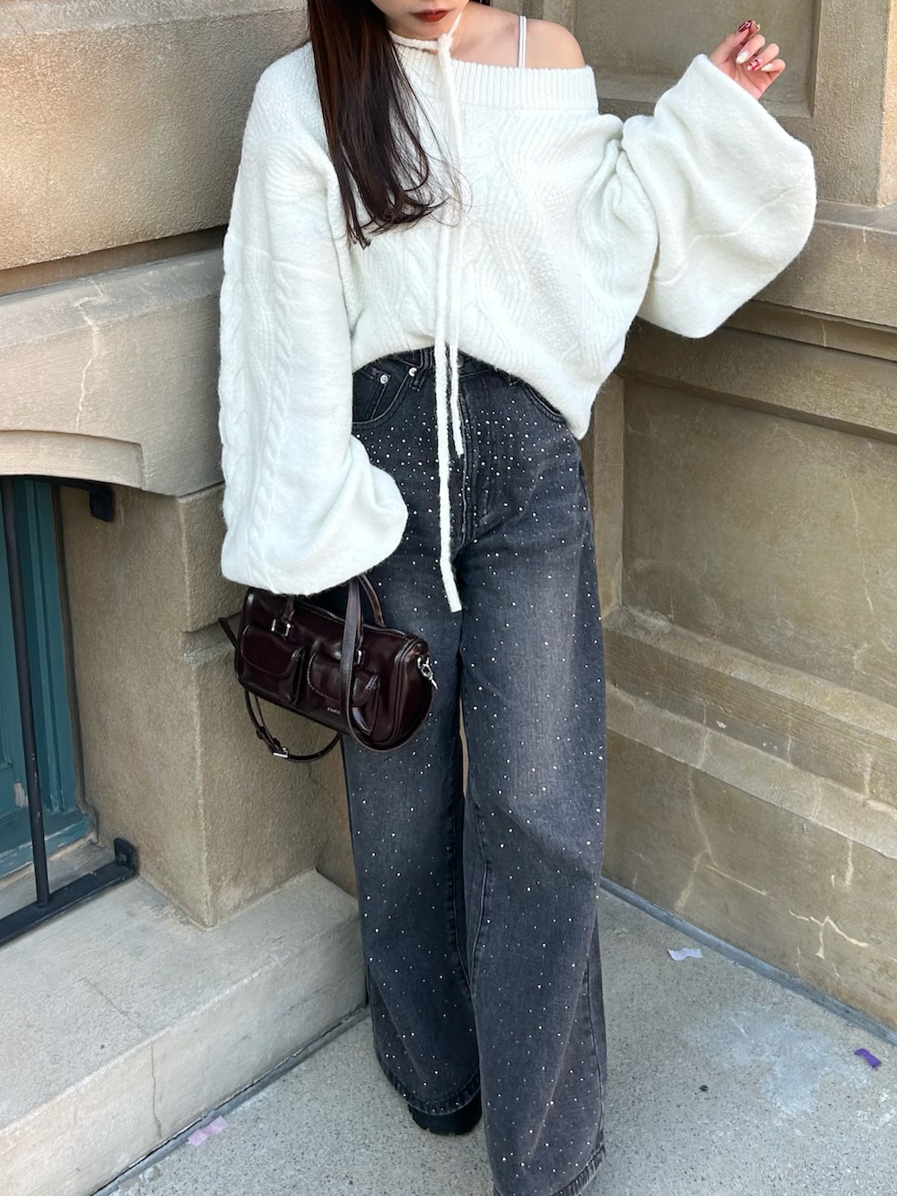 ブラック系のその他アウター、ホワイト系のニット/セーター、ブラウン系のボストンバッグを着用したレディースの冬コーディネートの4枚目の写真