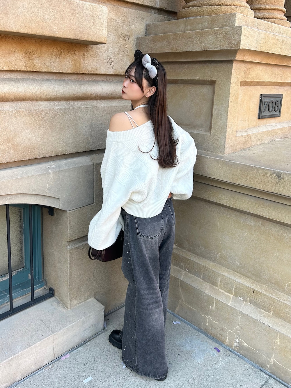 ブラック系のその他アウター、ホワイト系のニット/セーター、ブラウン系のボストンバッグを着用したレディースの冬コーディネートの3枚目の写真