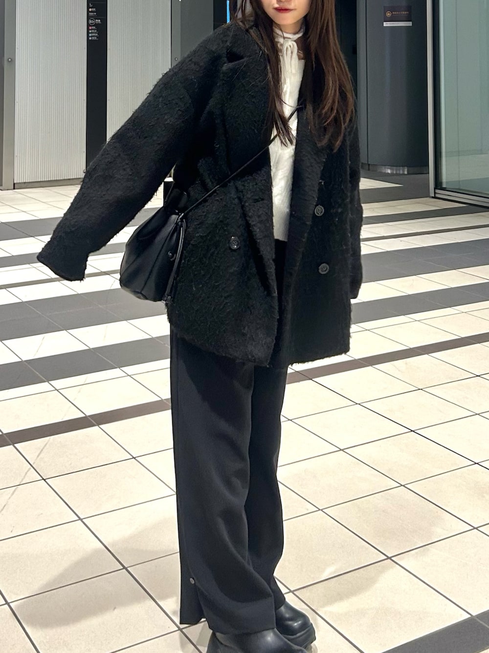 ブラック系のサンダル、ブラック系のその他パンツ、ブラック系のショルダーバッグを着用したレディースの春コーディネートの2枚目の写真