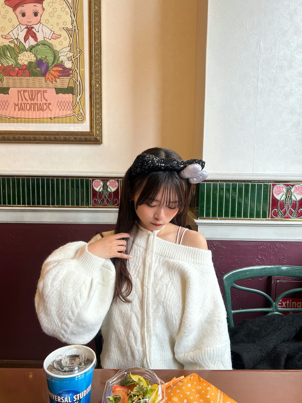 ブラック系のその他アウター、ホワイト系のニット/セーター、ブラウン系のボストンバッグを着用したレディースの冬コーディネートの5枚目の写真