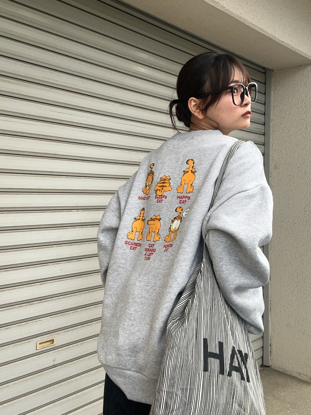 グレー系のスウェット、ホワイト系のスニーカー、グレー系のバッグを着用したレディースの冬コーディネートの3枚目の写真