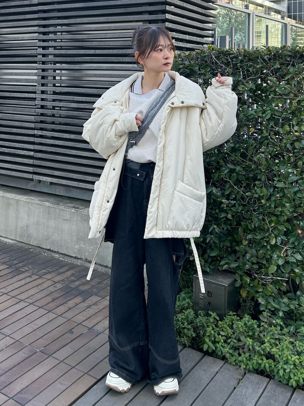 ホワイト系のスニーカー、ブラック系のデニムパンツ、ホワイト系のスウェットを着用したレディースの冬コーディネートの3枚目の写真