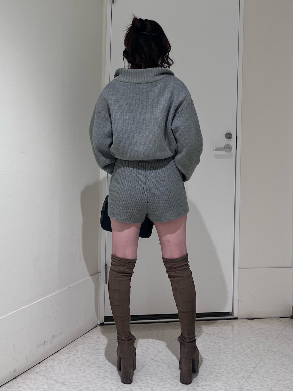 グレー系のつなぎ/オールインワン、ブラック系のハンドバッグ、ブラウン系のブーツを着用したレディースの冬コーディネートの3枚目の写真