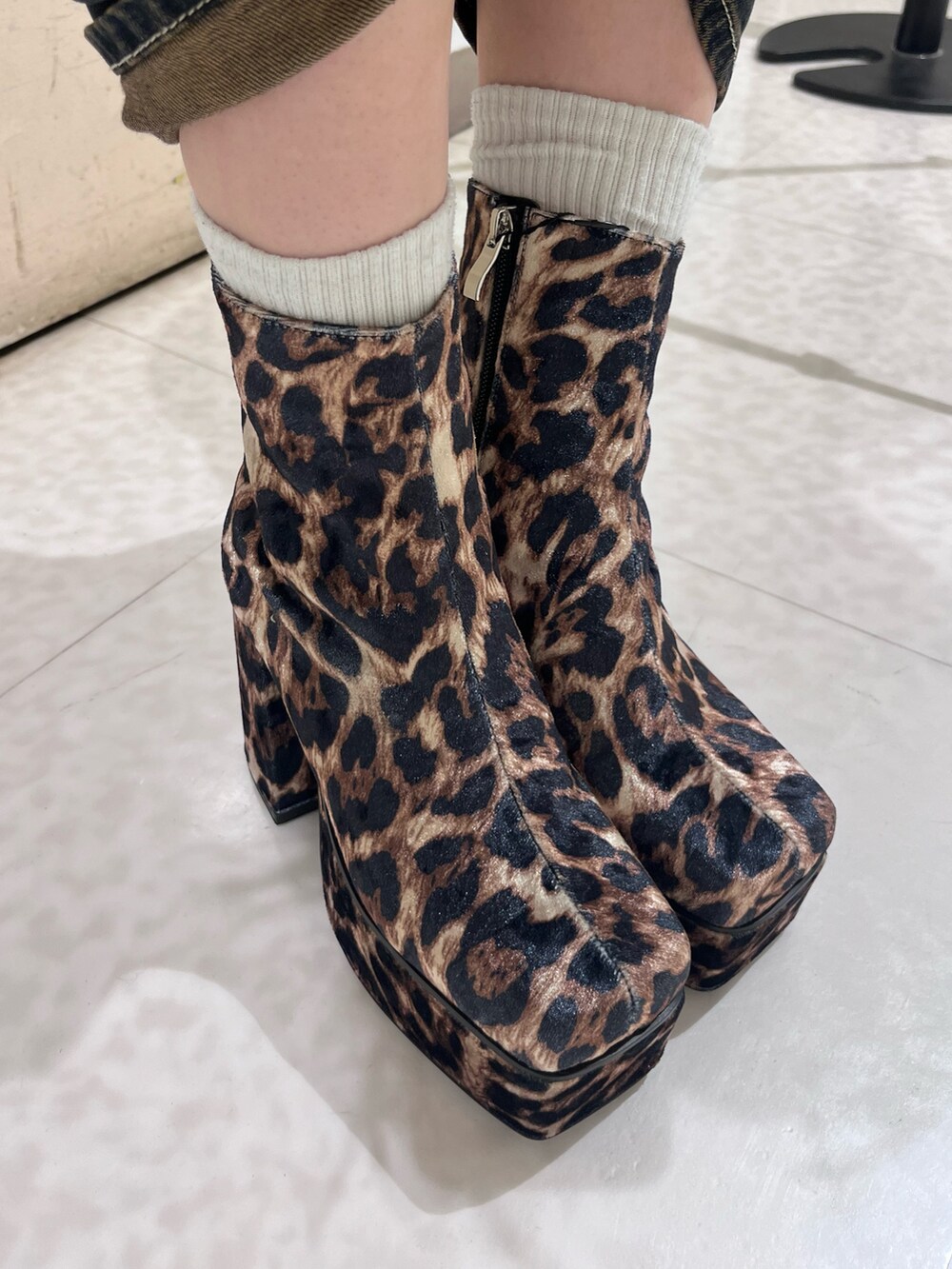 ホワイト系のニット/セーター、ブルー系のデニムパンツ、その他のブーツを着用したレディースの秋コーディネートの5枚目の写真