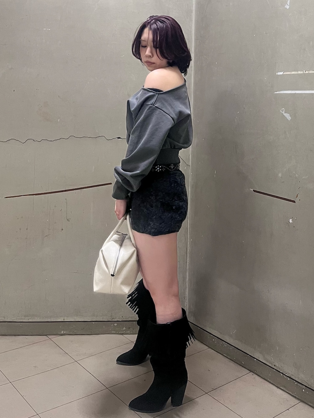 ブラック系のブーツ、ホワイト系のボストンバッグ、ブラック系のその他パンツを着用したレディースの冬コーディネートの2枚目の写真