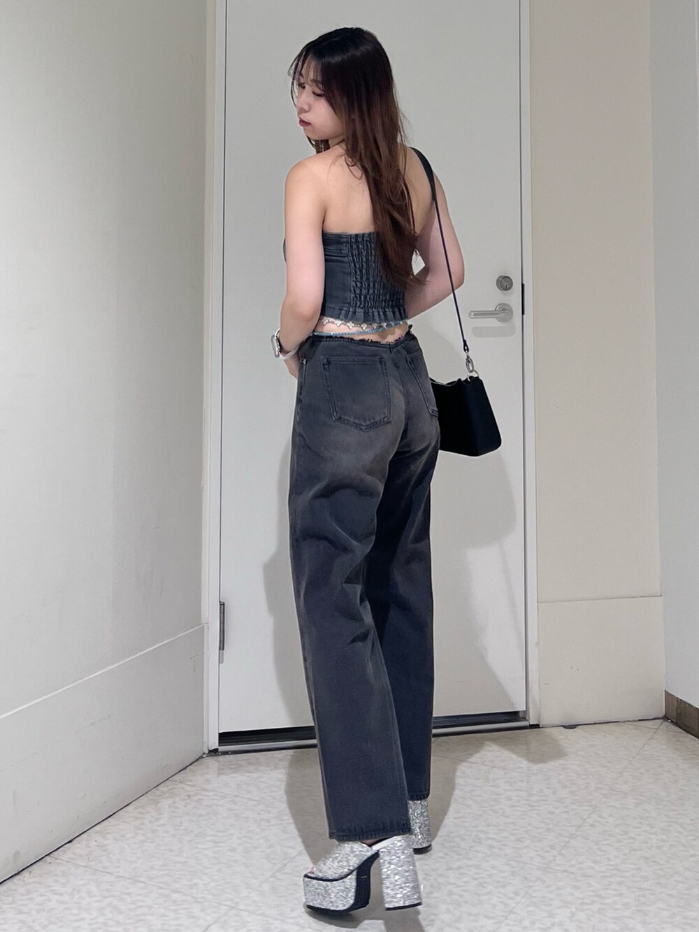 ブラック系のキャミソール、ブラック系のデニムパンツ、シルバー系のサンダルを着用したレディースの夏コーディネートの2枚目の写真