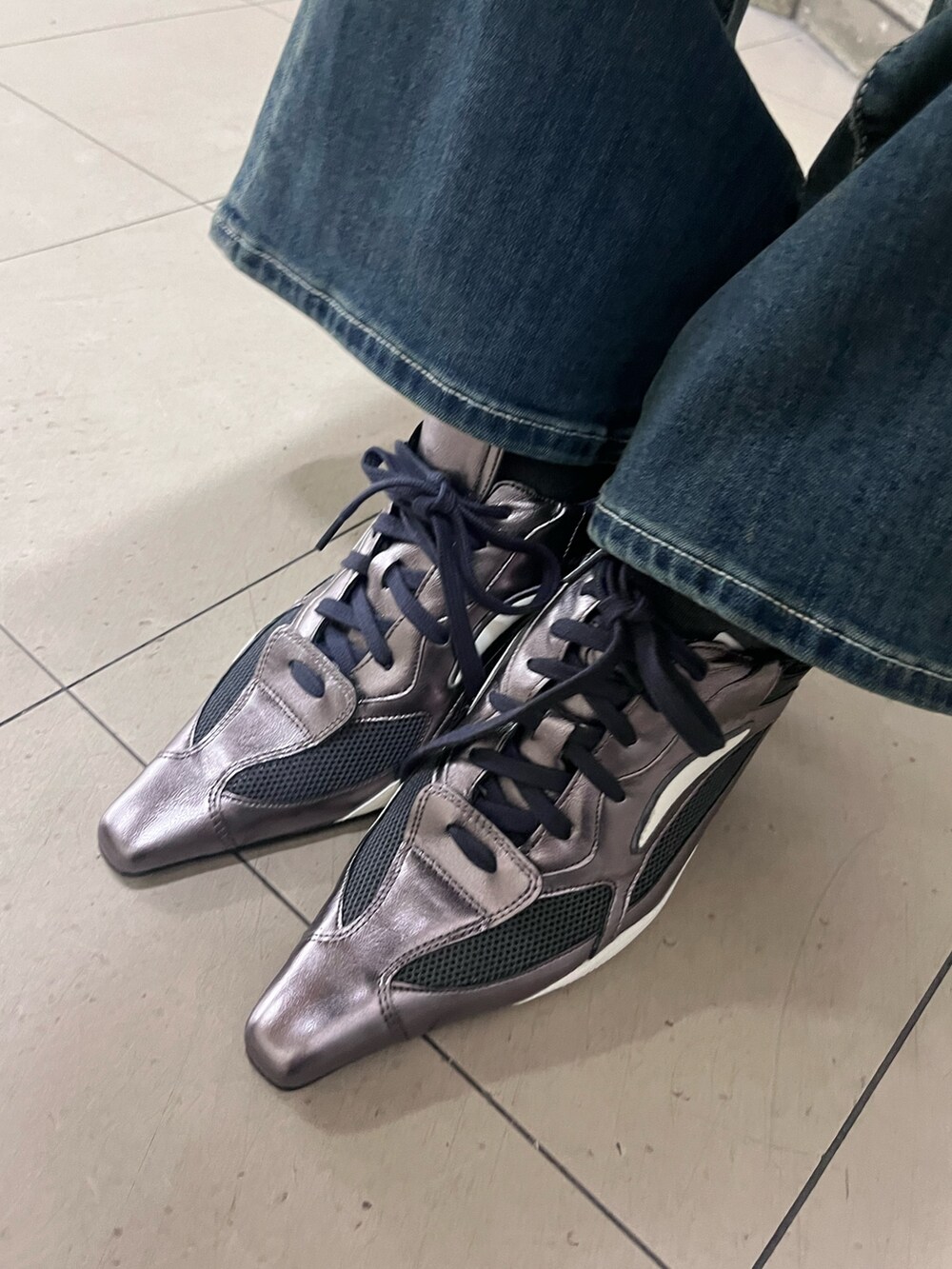 ブラック系のTシャツ/カットソー、ブルー系のデニムパンツ、シルバー系のパンプスを着用したレディースの春コーディネートの6枚目の写真