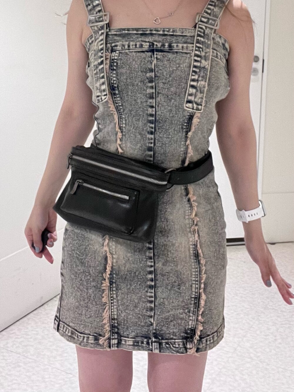 ベージュ系のワンピース、ブラック系のショルダーバッグ、ブラック系のブーツを着用したレディースの夏コーディネートの4枚目の写真