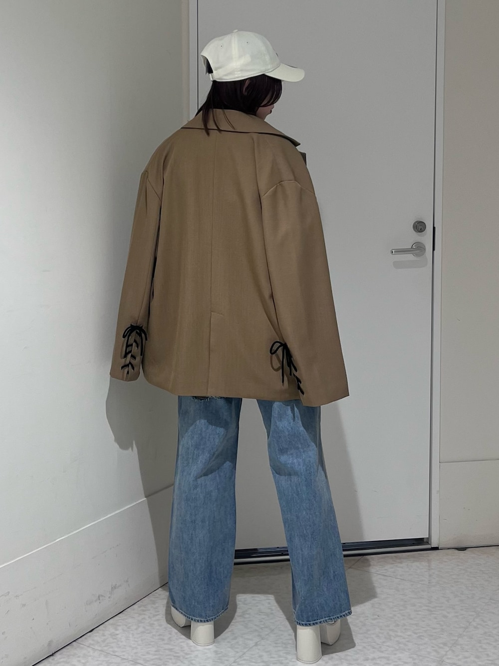 ブラウン系のテーラードジャケット、ブラウン系のシャツ/ブラウス、ブルー系のデニムパンツを着用したレディースの春コーディネートの3枚目の写真