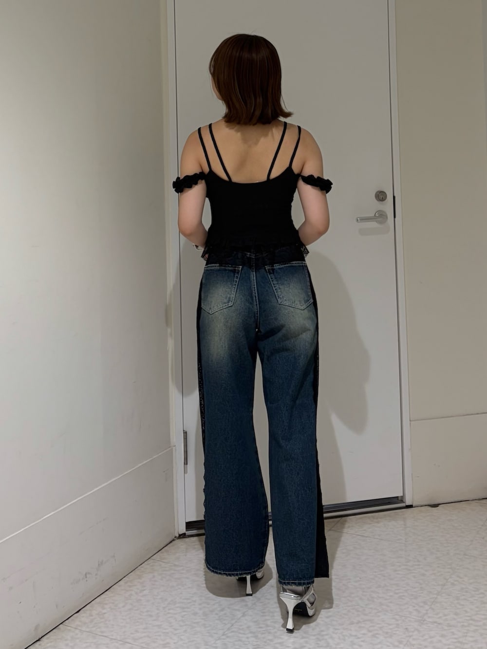 ブラック系のキャミソール、ブルー系のデニムパンツ、ブラック系のサンダルを着用したレディースの春コーディネートの3枚目の写真