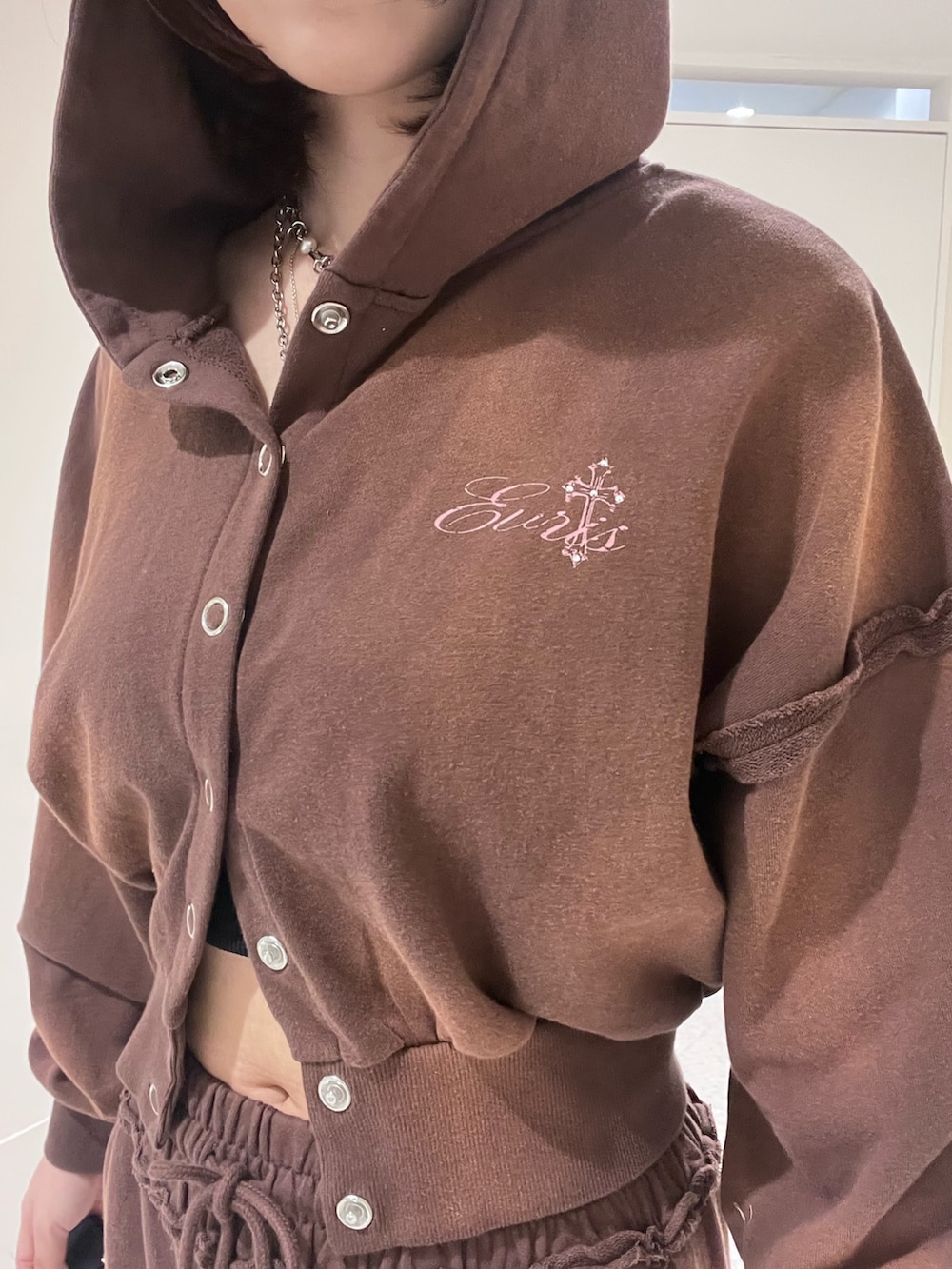 ブラウン系のパーカー、ブラウン系のスウェットパンツ、ブラック系のブーツを着用したレディースの春コーディネートの4枚目の写真