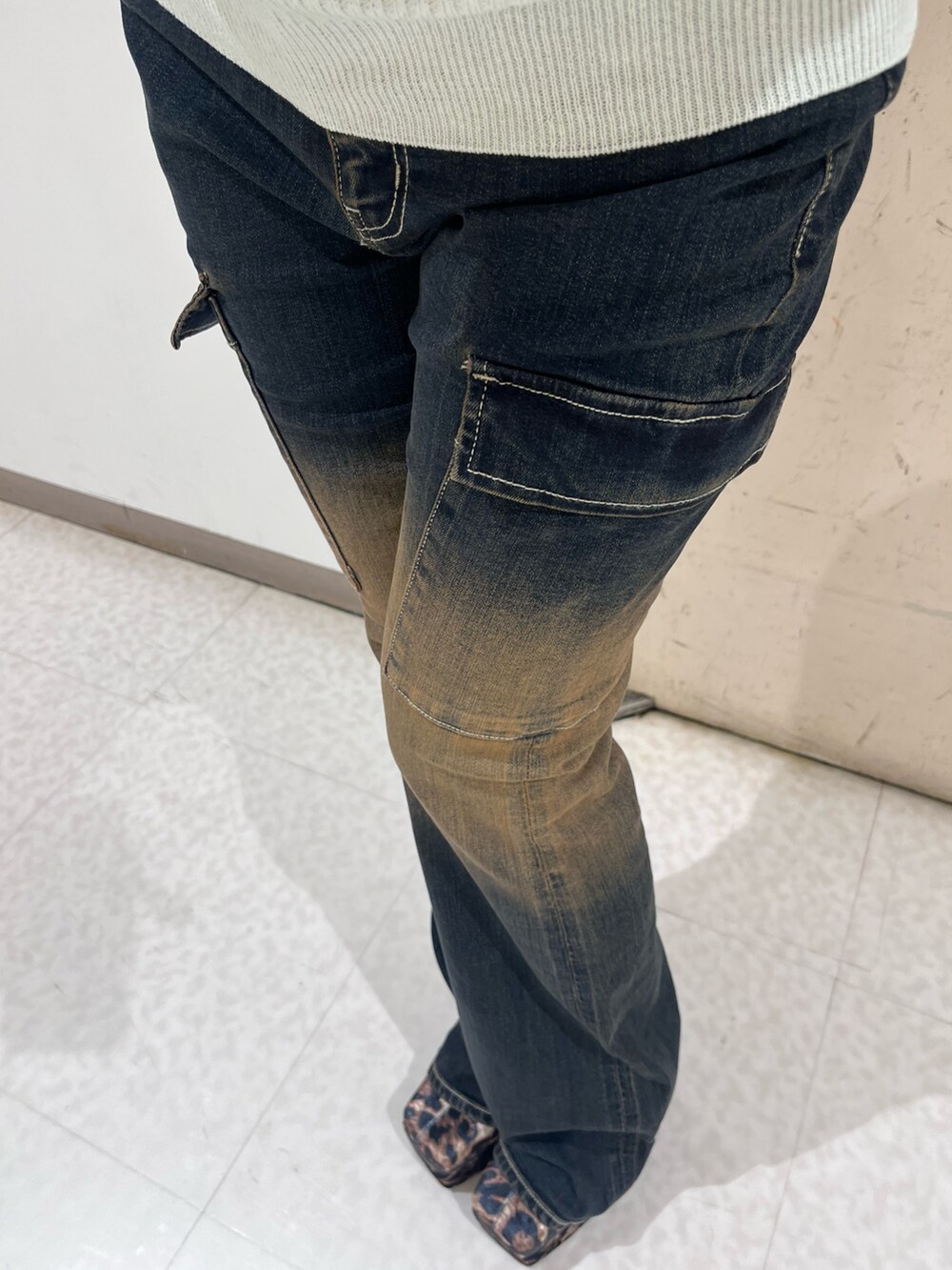 ホワイト系のニット/セーター、ブルー系のデニムパンツ、その他のブーツを着用したレディースの秋コーディネートの4枚目の写真