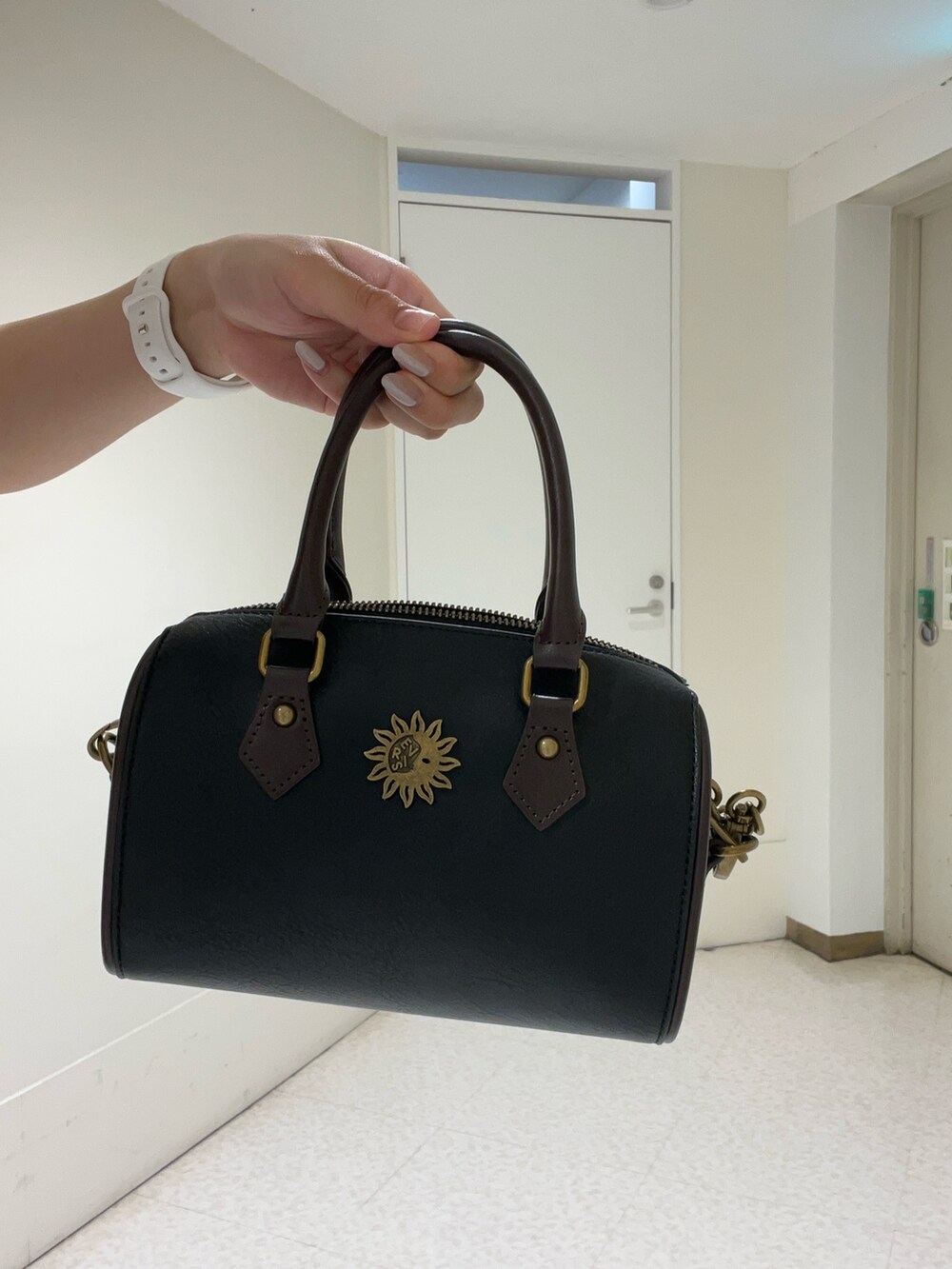 ピンク系のキャミソール、ブルー系のデニムパンツ、ブラック系のショルダーバッグを着用したレディースの春コーディネートの5枚目の写真