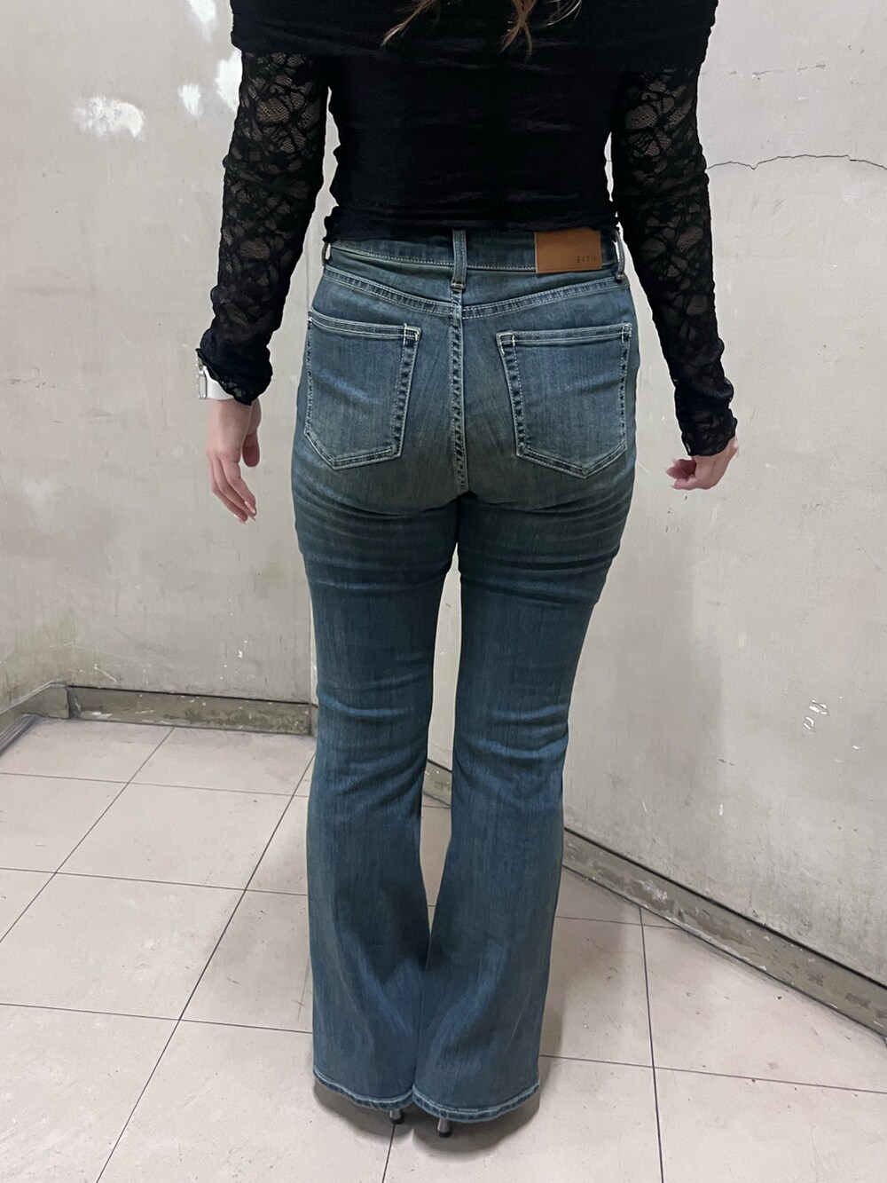 ブラック系のTシャツ/カットソー、ブルー系のデニムパンツ、シルバー系のパンプスを着用したレディースの春コーディネートの5枚目の写真