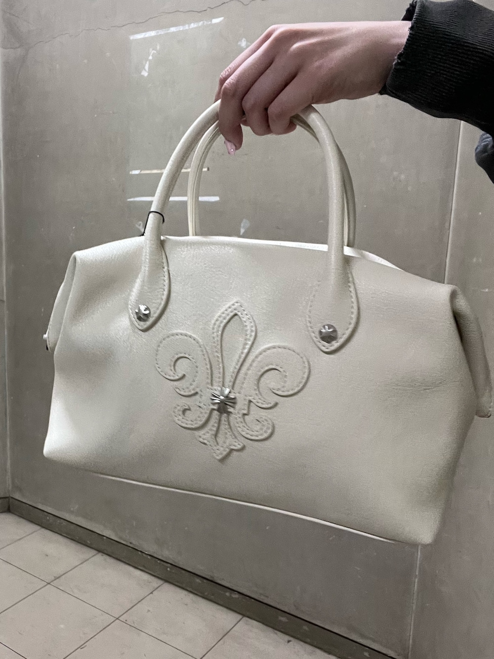 ブラック系のブーツ、ホワイト系のボストンバッグ、ブラック系のその他パンツを着用したレディースの冬コーディネートの5枚目の写真