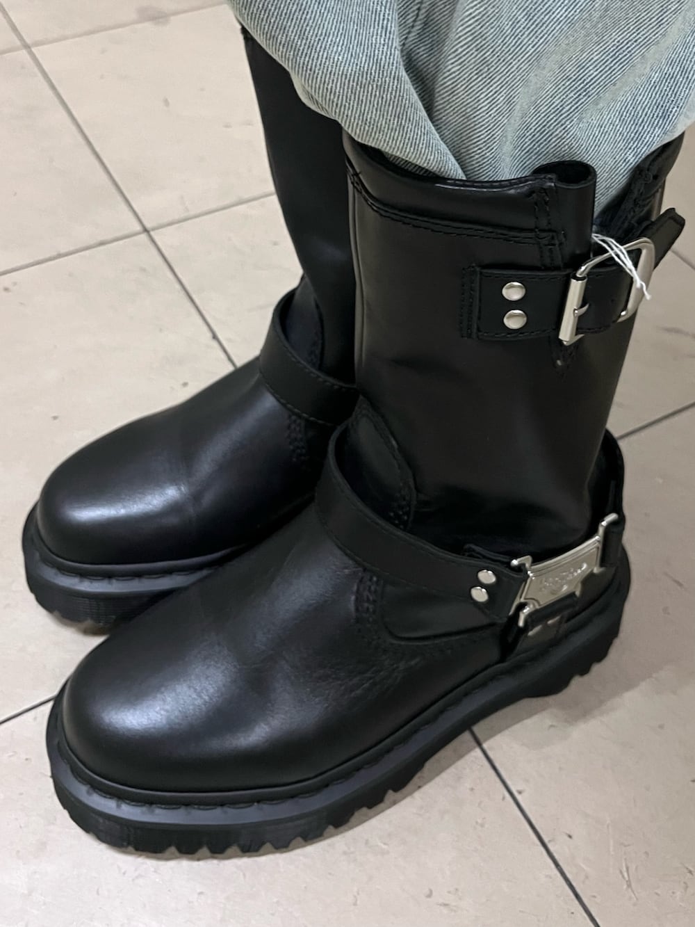 ホワイト系のチェスターコート、レッド系のニット/セーター、ブルー系のデニムパンツを着用したレディースの冬コーディネートの7枚目の写真