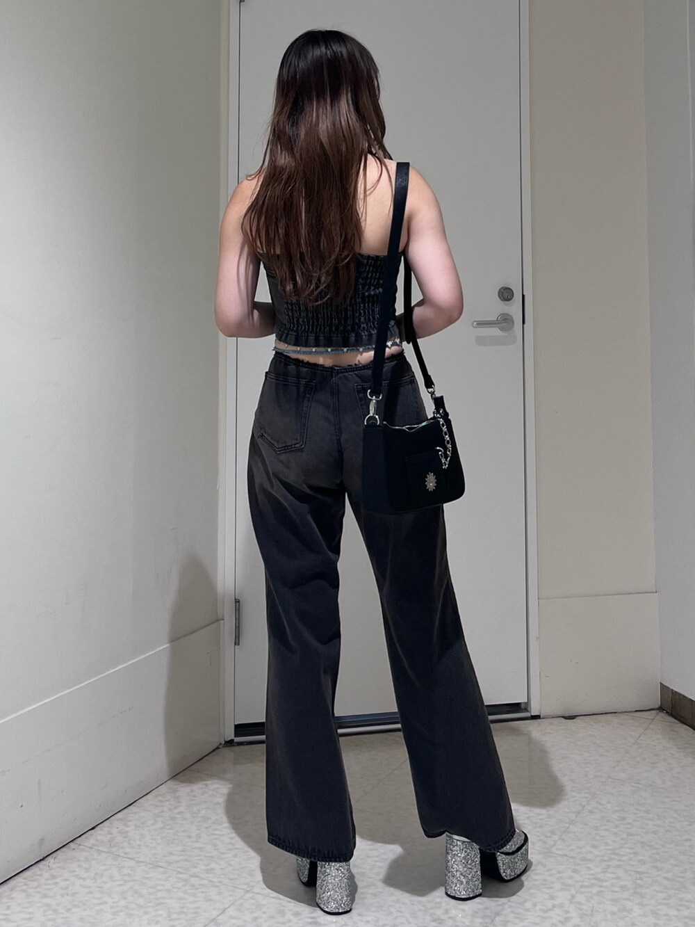 ブラック系のキャミソール、ブラック系のデニムパンツ、シルバー系のサンダルを着用したレディースの夏コーディネートの3枚目の写真
