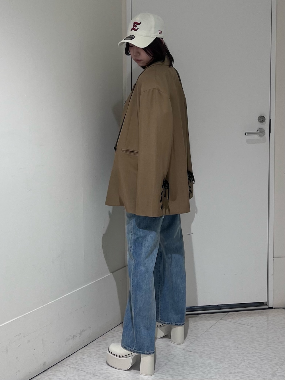 ブラウン系のテーラードジャケット、ブラウン系のシャツ/ブラウス、ブルー系のデニムパンツを着用したレディースの春コーディネートの2枚目の写真