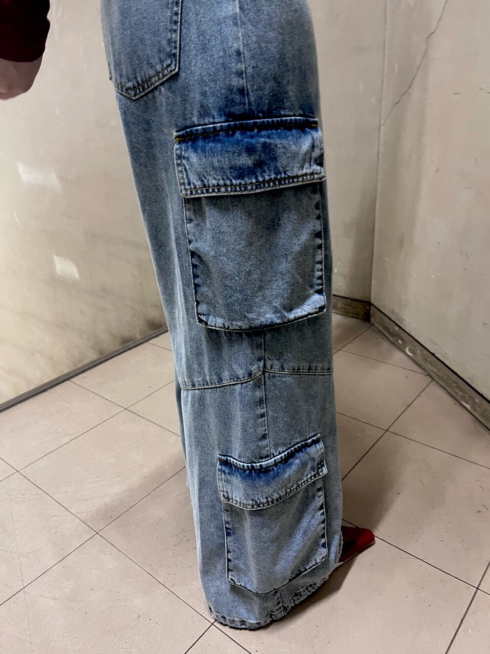 レッド系のTシャツ/カットソー、ブルー系のデニムパンツ、ブラック系のショルダーバッグを着用したレディースの春コーディネートの6枚目の写真