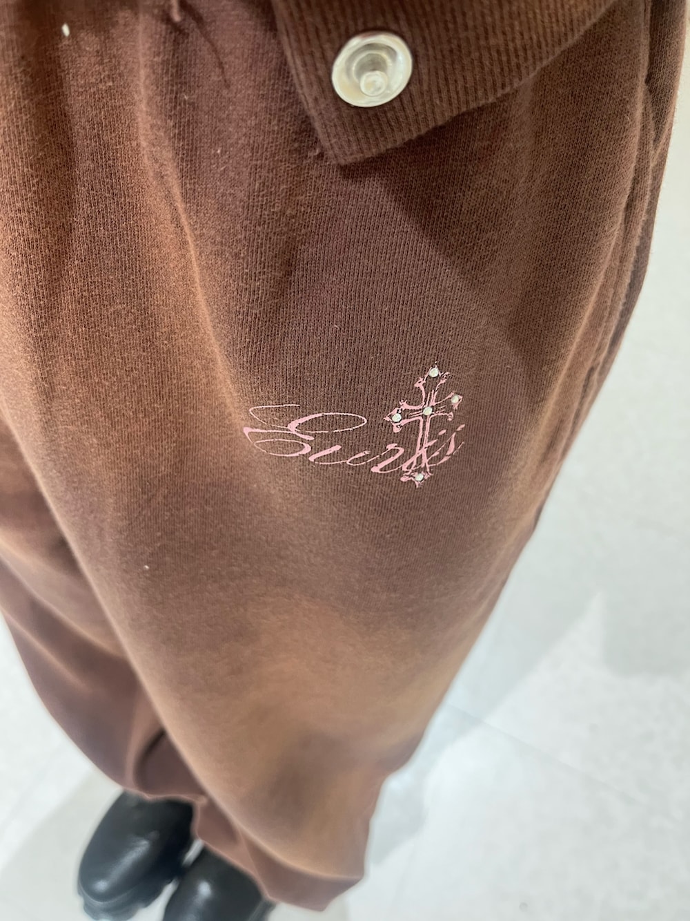 ブラウン系のパーカー、ブラウン系のスウェットパンツ、ブラック系のブーツを着用したレディースの春コーディネートの5枚目の写真