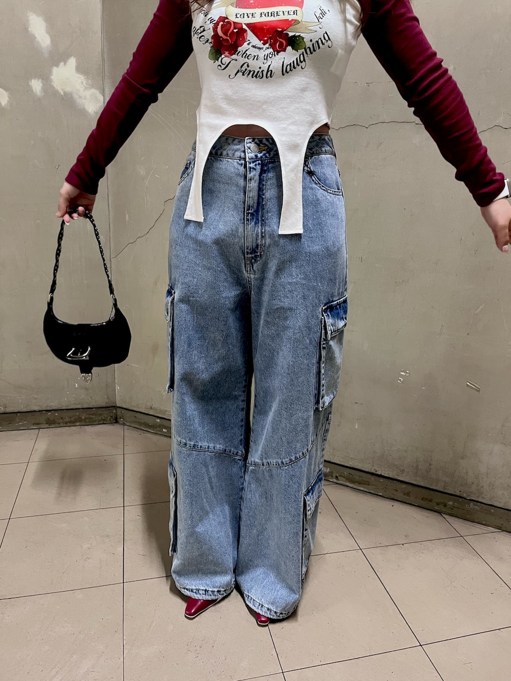 レッド系のTシャツ/カットソー、ブルー系のデニムパンツ、ブラック系のショルダーバッグを着用したレディースの春コーディネートの5枚目の写真