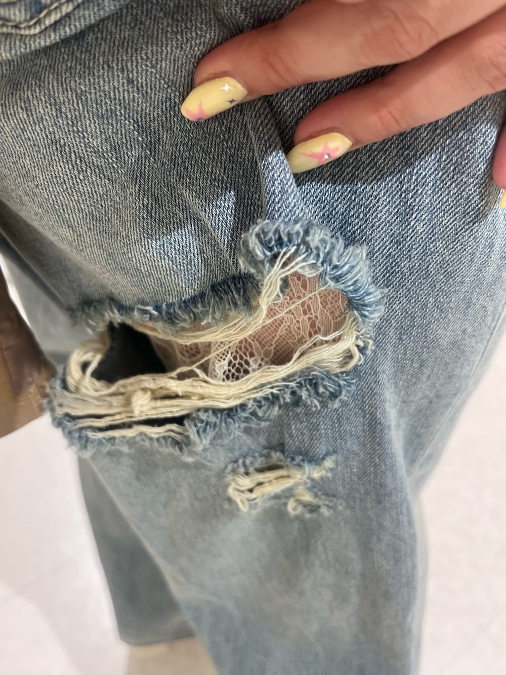 ブラウン系のテーラードジャケット、ブラウン系のシャツ/ブラウス、ブルー系のデニムパンツを着用したレディースの春コーディネートの6枚目の写真