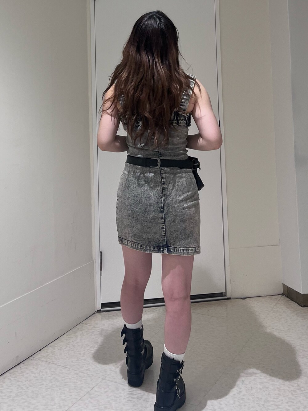 ベージュ系のワンピース、ブラック系のショルダーバッグ、ブラック系のブーツを着用したレディースの夏コーディネートの2枚目の写真