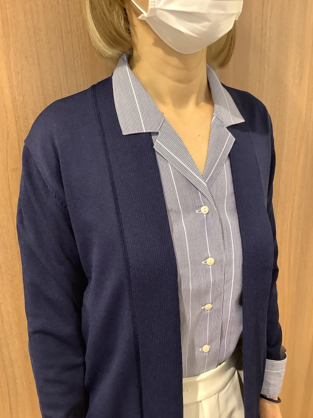 ブルー系のビジネスシャツ、ブルー系のカーディガン/ボレロ、ブラック系のスニーカーを着用したレディースの春コーディネートの2枚目の写真