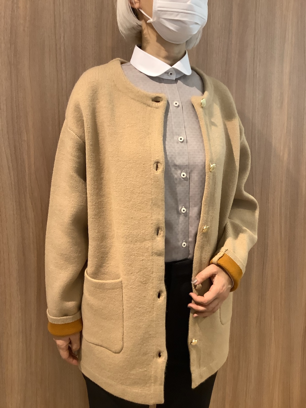 ブラウン系のビジネスシャツ、ブルー系のカーディガン/ボレロ、ブラック系のローファーを着用したレディースの冬コーディネートの2枚目の写真