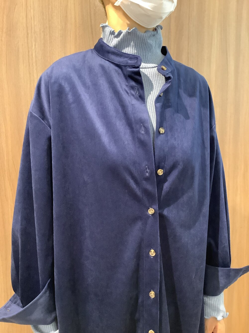 ブルー系のニット/セーター、ブルー系のシャツ/ブラウス、ブラック系のブーツを着用したレディースの秋コーディネートの2枚目の写真