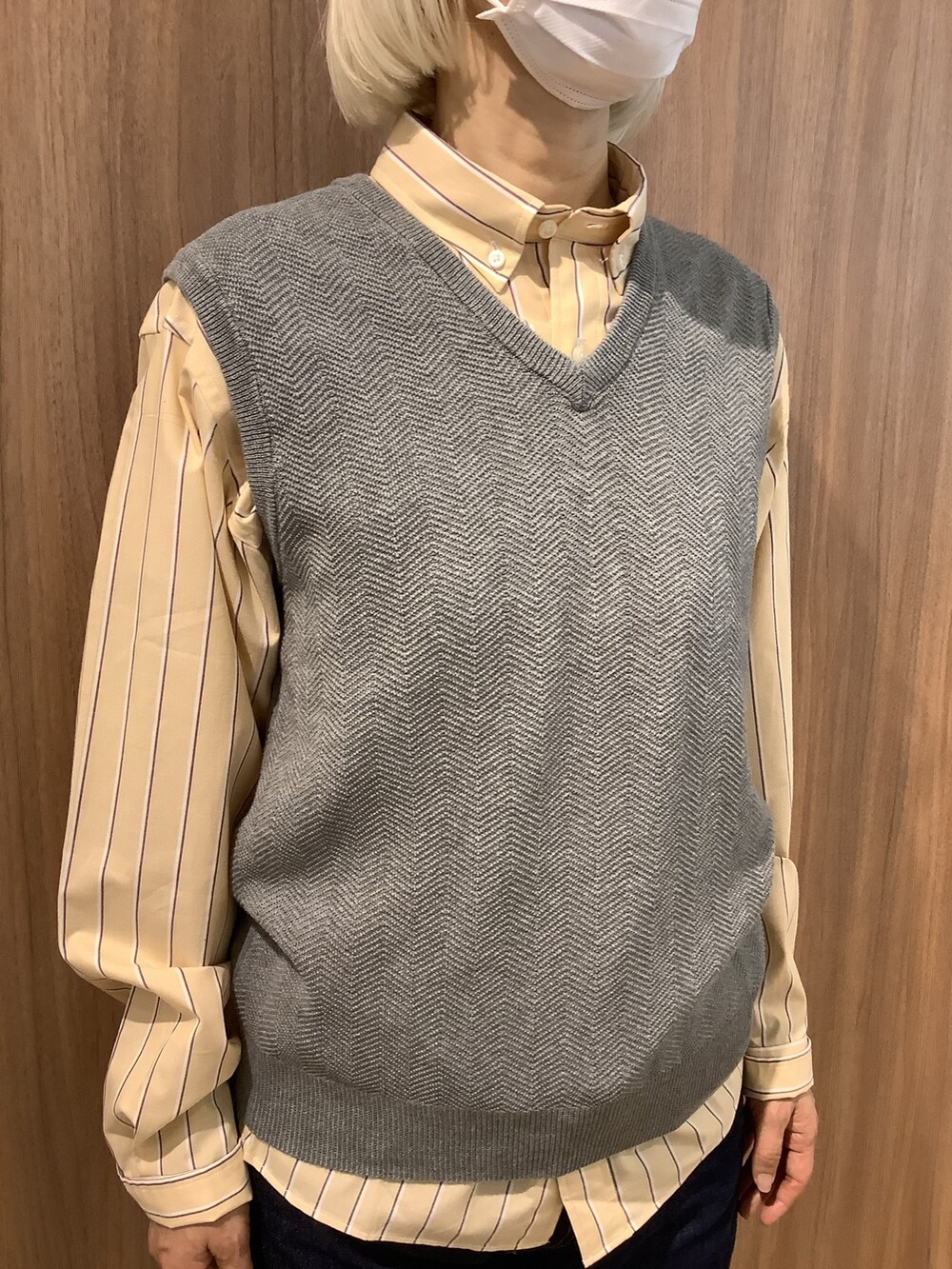 ベージュ系のシャツ/ブラウス、グレー系のベスト、ブルー系のデニムパンツを着用したレディースの春コーディネートの2枚目の写真