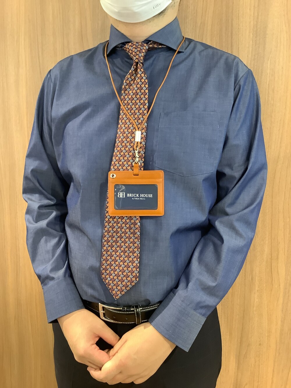 ブルー系のビジネスシャツ、ブラウン系のネクタイ、ブルー系のスラックスを着用したメンズの秋コーディネートの2枚目の写真