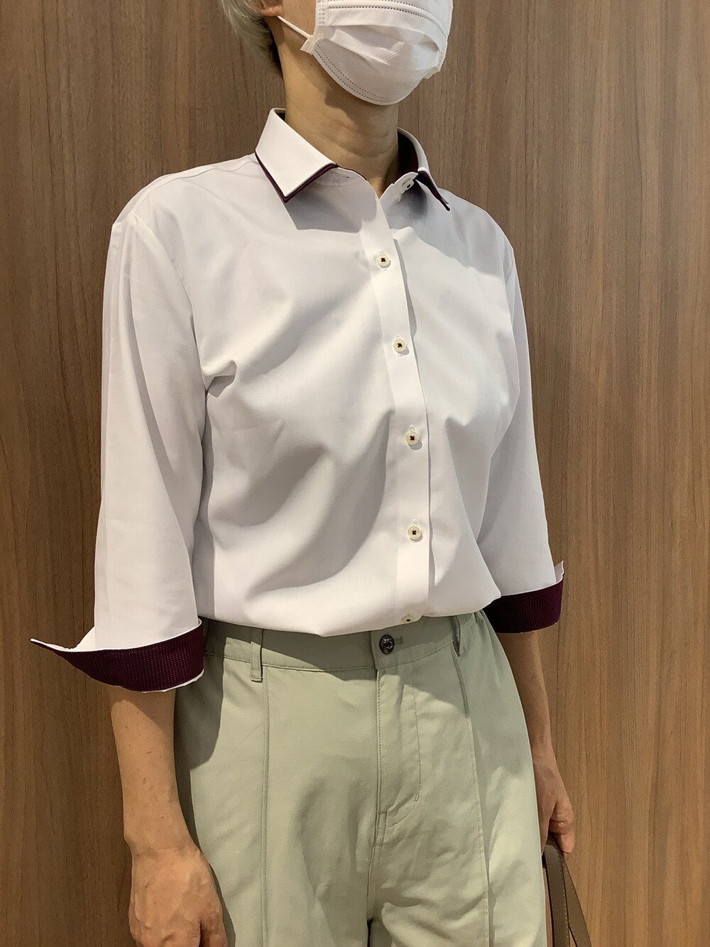 ホワイト系のビジネスシャツ、ベージュ系のパンプス、ベージュ系のトートバッグを着用したレディースの夏コーディネートの2枚目の写真
