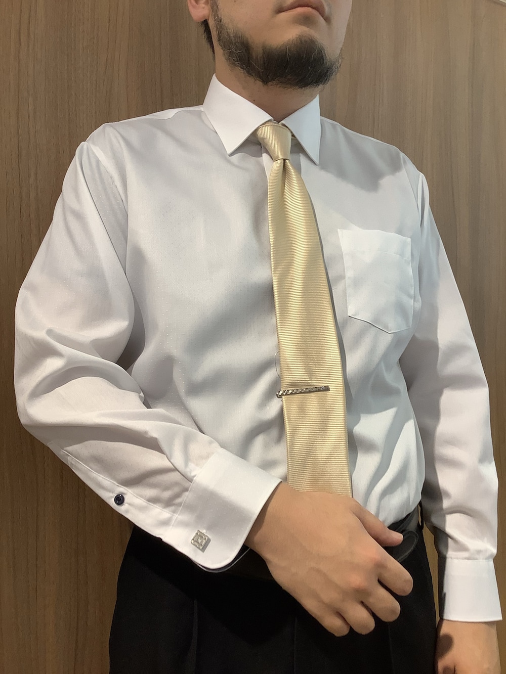 イエロー系のネクタイ、ホワイト系のビジネスシャツ、シルバー系のネクタイピンを着用したメンズの春コーディネートの2枚目の写真