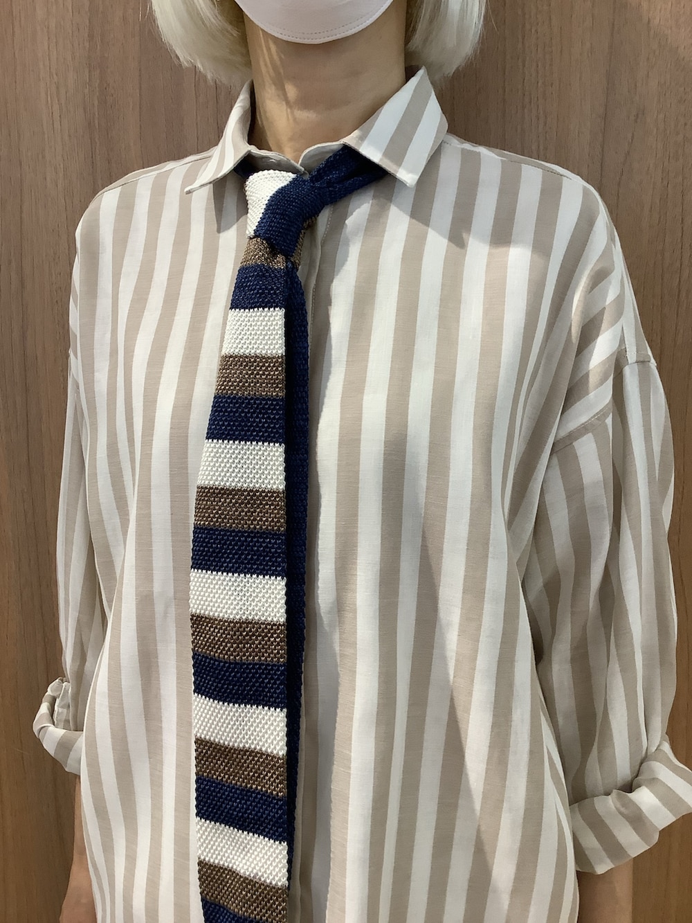 ベージュ系のシャツ/ブラウス、ブラック系のスニーカー、ブルー系のネクタイを着用したレディースの夏コーディネートの2枚目の写真