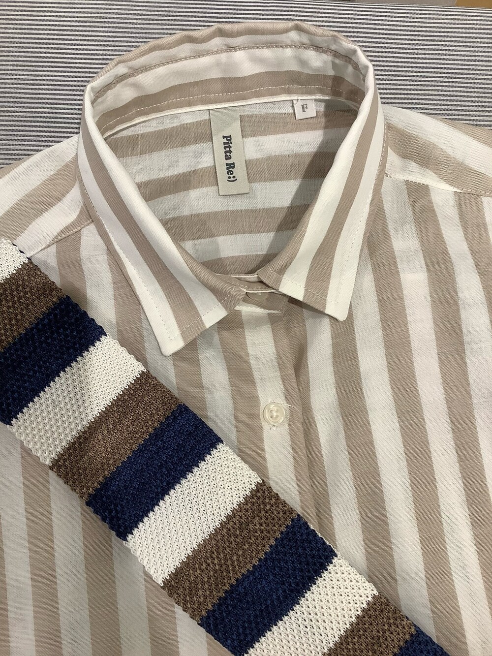 ベージュ系のシャツ/ブラウス、ブラック系のスニーカー、ブルー系のネクタイを着用したレディースの夏コーディネートの3枚目の写真