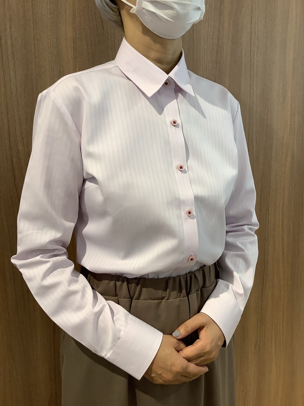 ピンク系のビジネスシャツ、パープル系のニット/セーター、ベージュ系のスカートを着用したレディースの秋コーディネートの4枚目の写真