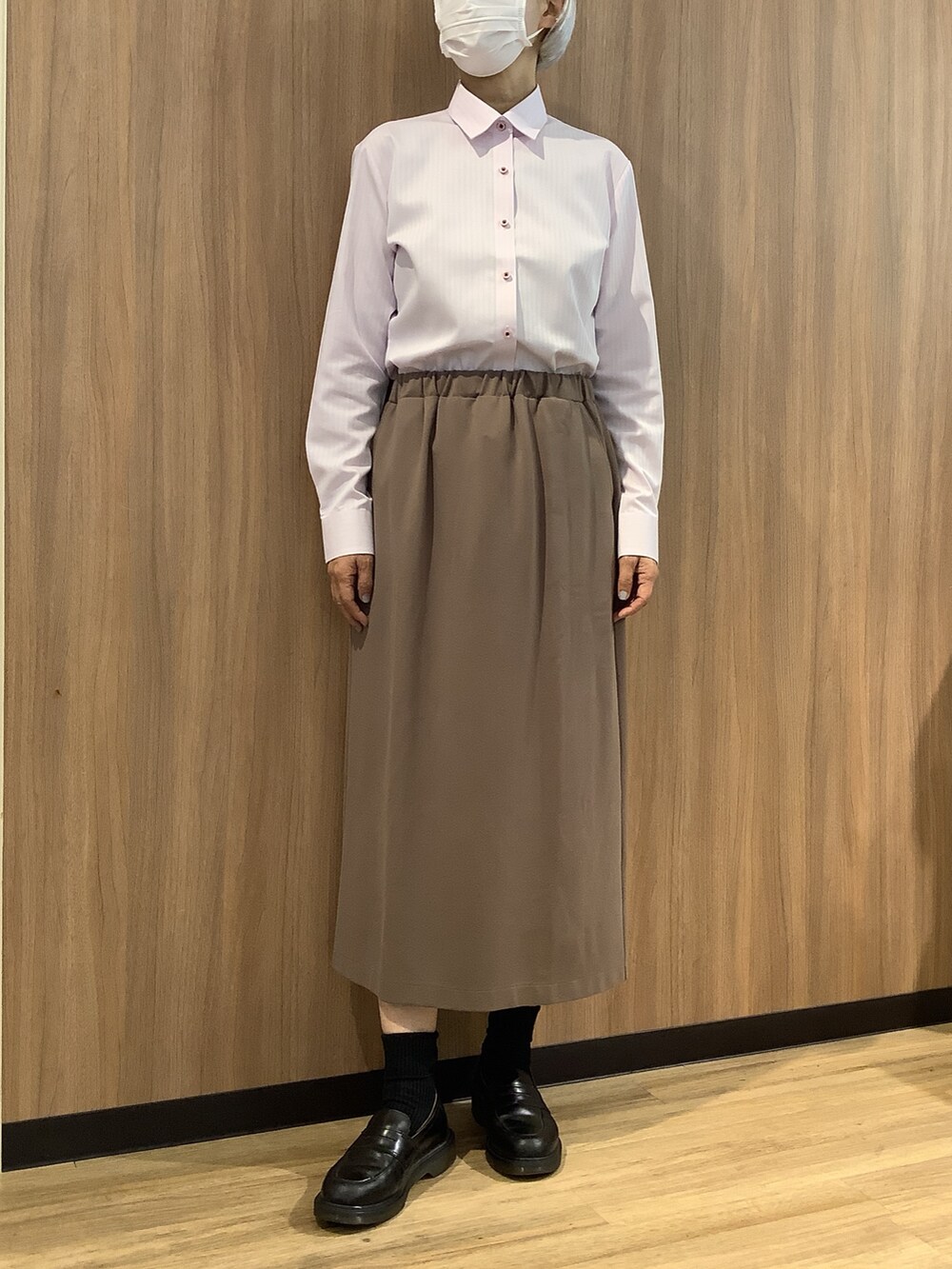 ピンク系のビジネスシャツ、パープル系のニット/セーター、ベージュ系のスカートを着用したレディースの秋コーディネートの3枚目の写真