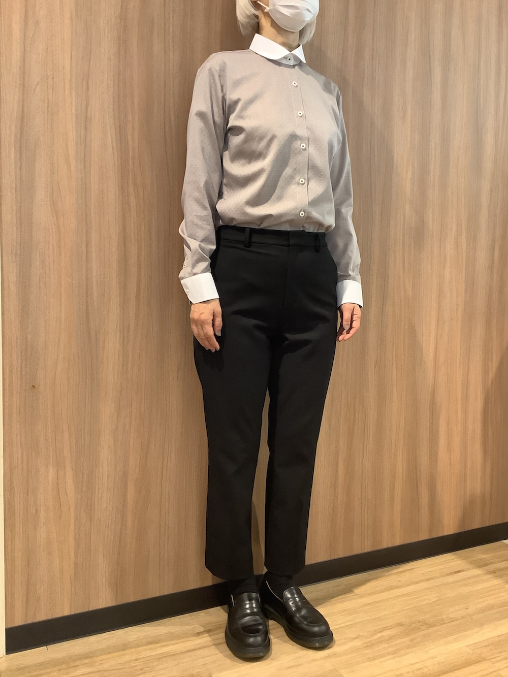 ブラウン系のビジネスシャツ、ブルー系のカーディガン/ボレロ、ブラック系のローファーを着用したレディースの冬コーディネートの4枚目の写真