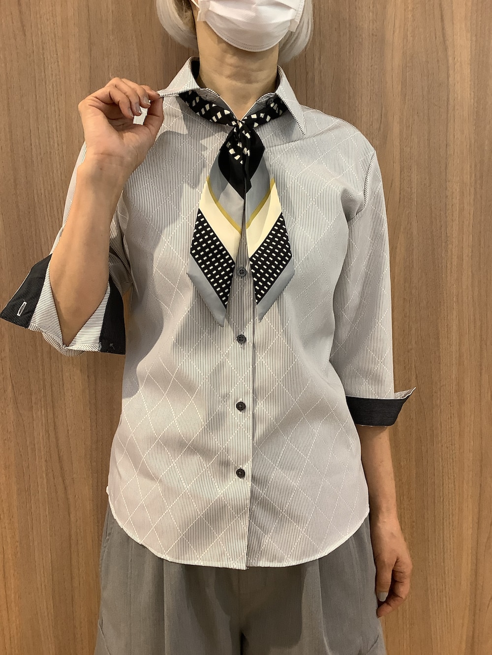 グレー系のビジネスシャツ、ブラック系のバンダナ/スカーフを着用したレディースの春コーディネートの2枚目の写真