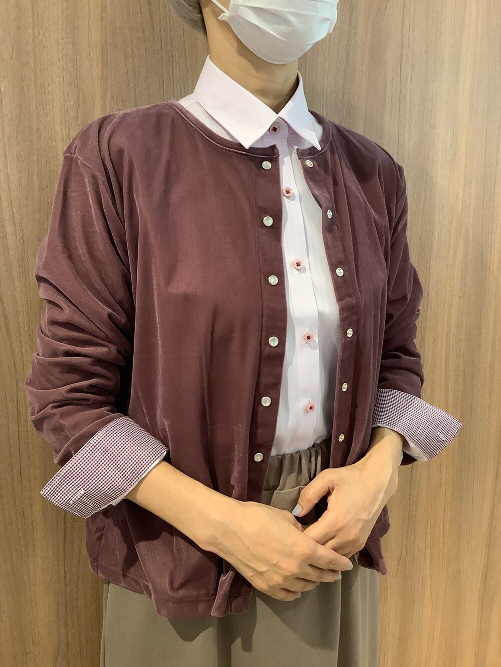 ピンク系のビジネスシャツ、パープル系のニット/セーター、ベージュ系のスカートを着用したレディースの秋コーディネートの2枚目の写真