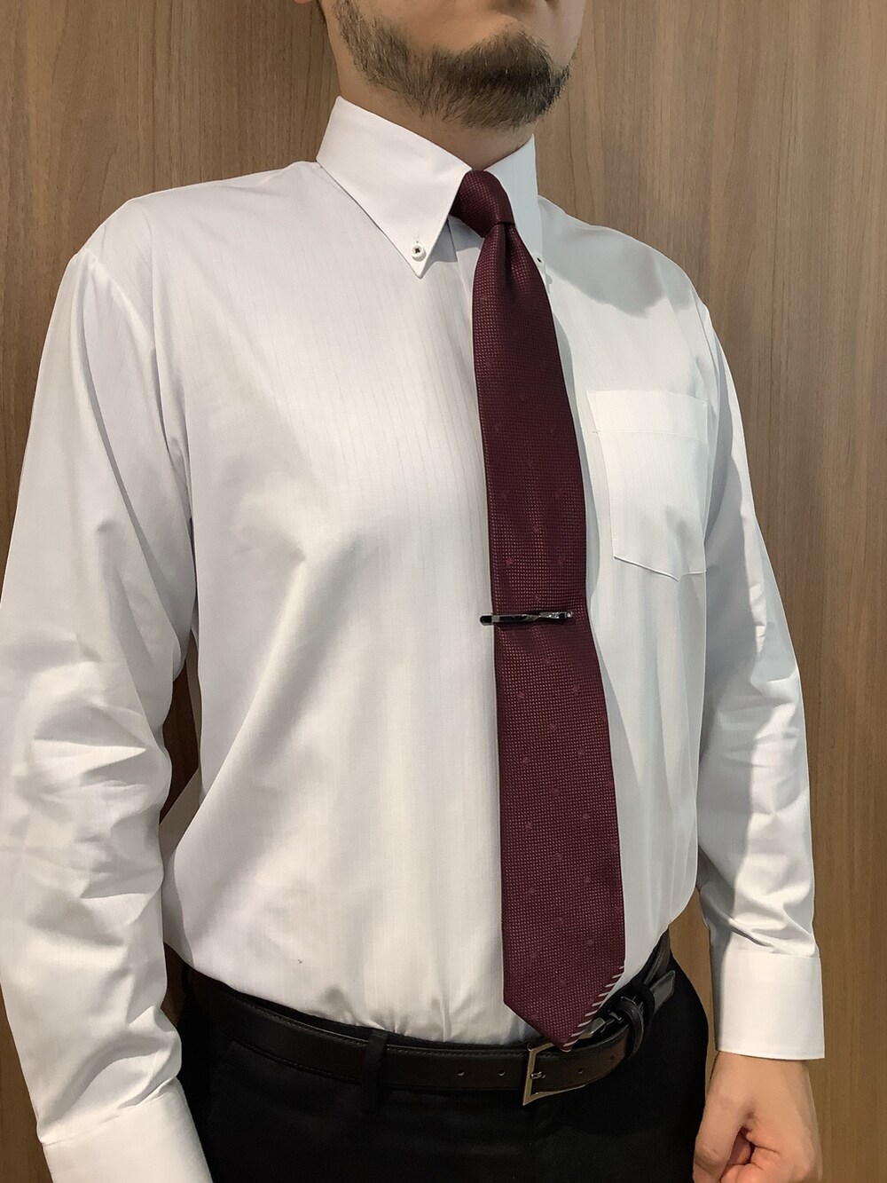 ブラック系のネクタイピン、ホワイト系のビジネスシャツ、レッド系のネクタイを着用したメンズの春コーディネートの2枚目の写真