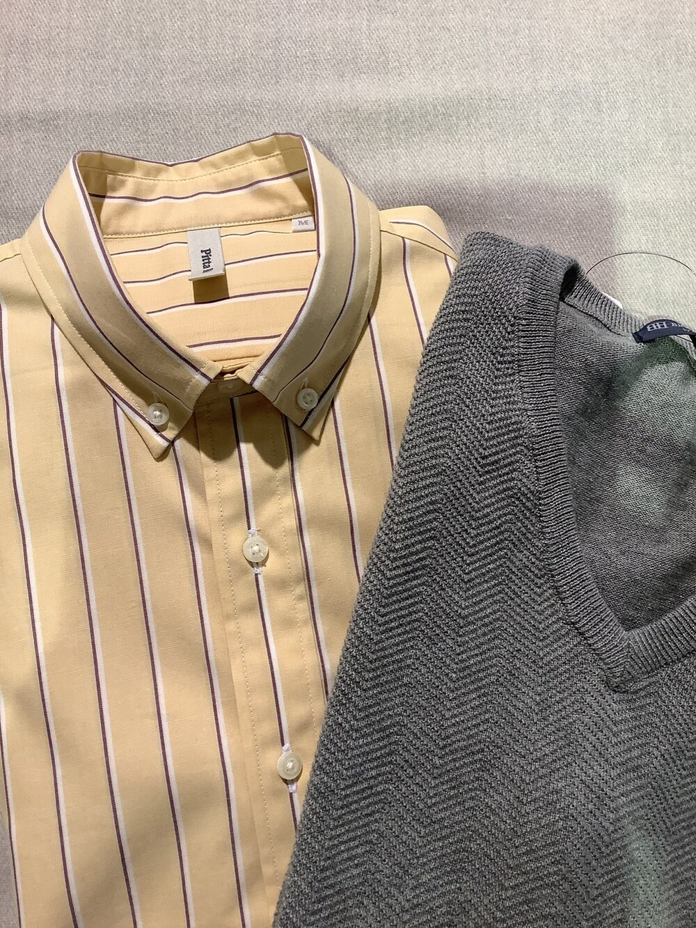 ベージュ系のシャツ/ブラウス、グレー系のベスト、ブルー系のデニムパンツを着用したレディースの春コーディネートの3枚目の写真