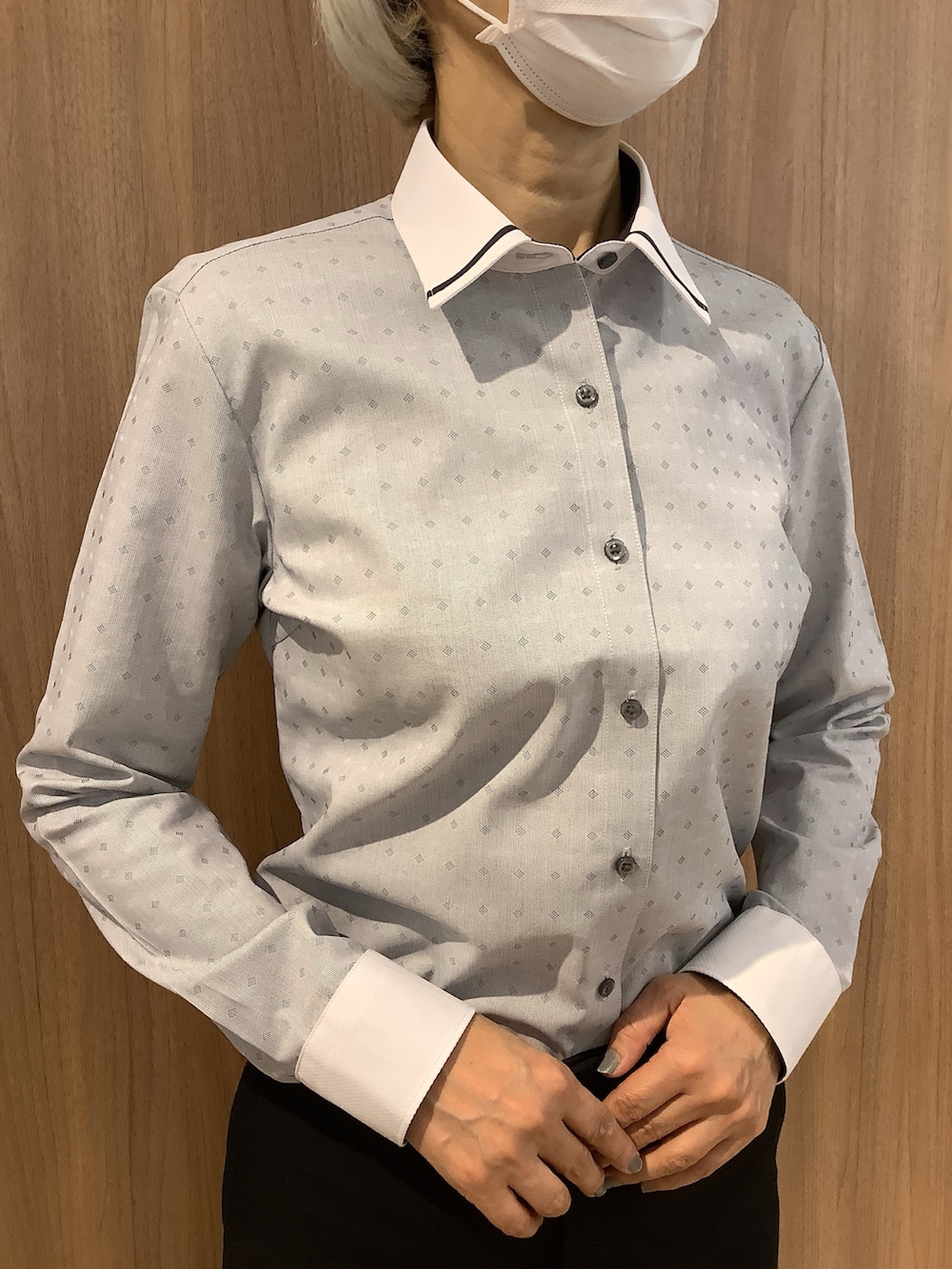 グレー系のビジネスシャツ、ブラック系のスラックス、ブラック系のローファーを着用したレディースの冬コーディネートの2枚目の写真