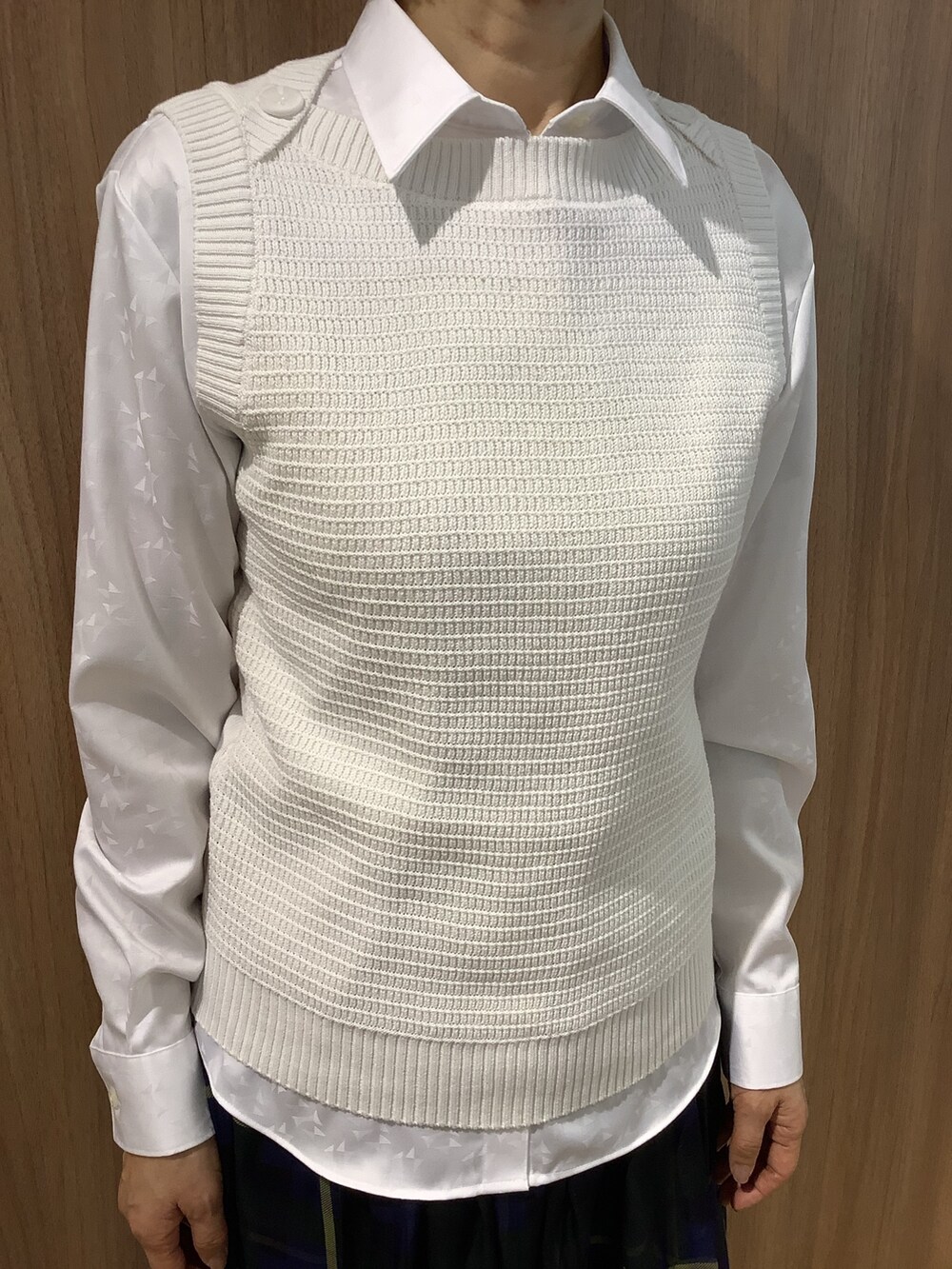 ホワイト系のビジネスシャツ、ホワイト系のベスト、ブラック系のローファーを着用したレディースの春コーディネートの2枚目の写真